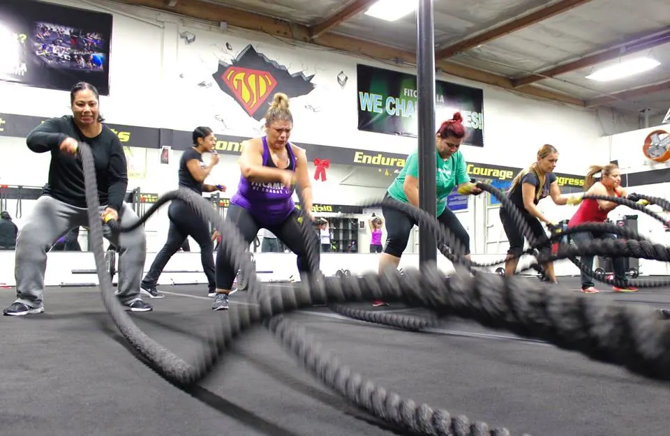 A strength and conditioning class working battle ropes